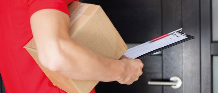 Paketbote bringt Paket zur Haustür