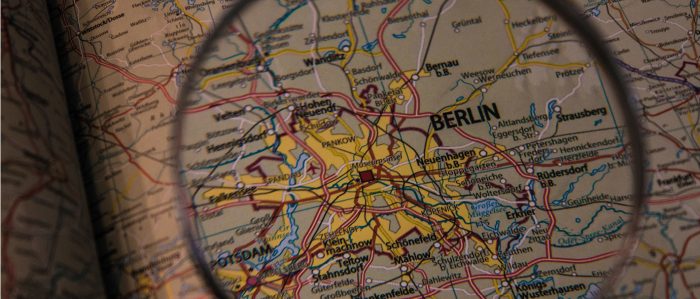 Blick durch eine Lupe auf eine Landkarte, die die Stadt Berlin zeigt