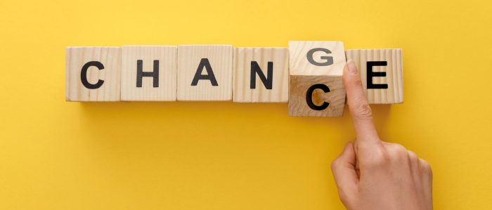 Scrabbel-Buchstaben-Würfel zeigen das Wort "Change", das jemand zum Wort "Chance" weiterdreht..