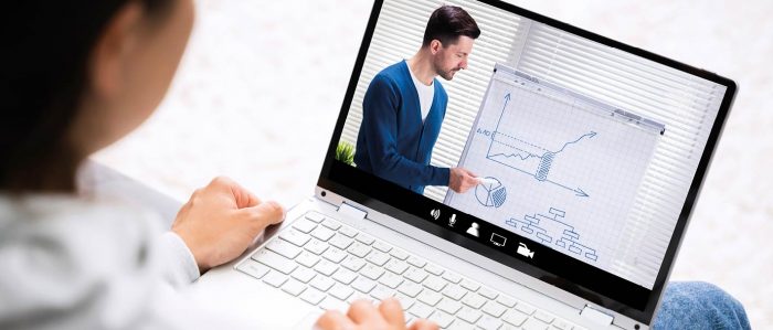 Junge Frau nimmt mit Ihrem Tablet von zu Hause aus an einem Onlinekurs teil.