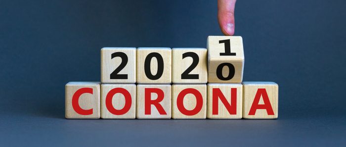 Ein Finger dreht den letzten Würfel einer Würfelreihe, so dass aus dem gezeigten "Corona 2020" ein "Coronal 2021" wird.