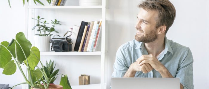 Smiling man at desk in office looking sideways