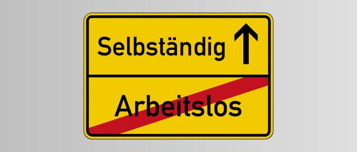Gelbes Ortsschild, auf dem unten ein durchgestrichenes „arbeitslos“ steht und oben ein „selbständig“
