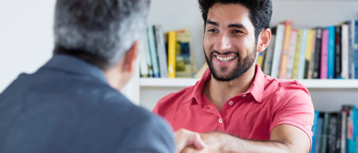 Zwei Männer begrüßen sich mit Handschlag.