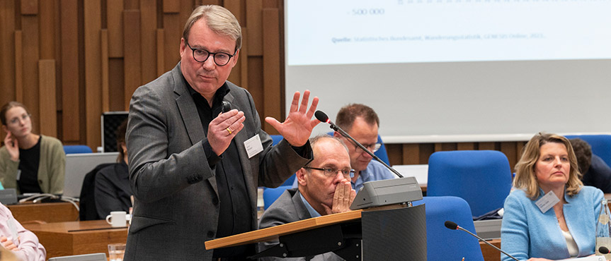 Das Bild zeigt Herbert Brücker bei seinem Vortrag am Rednerpult.