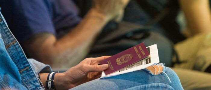 Woman waiting for her flight in the airport lobby with an Italian passport and boarding pass in her hand.