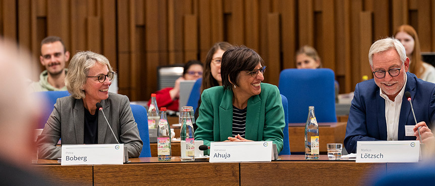 Das Bild zeigt die Podiumsgäste bei der Veranstaltung Wissenschaft trifft Praxis, von Links Markus Lötzsch und Vanessa Ahuja am Tisch sitzen.