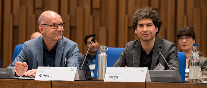 Das Bild zeigt die Podiumsgäste bei der Veranstaltung Wissenschaft trifft Praxis, von Links Ulrich Walwei und Martin Varga am Tisch sitzen.