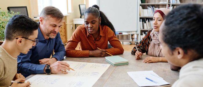 Zwei Männer und zwei Frauen verschiedener Abstammung und verschiedenen Alters nehmen an einem Kurs teil.
