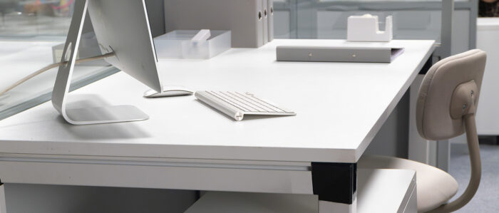 Unbesetzter Arbeitsplatz mit Schreibtisch und Computer in einem Büroraum